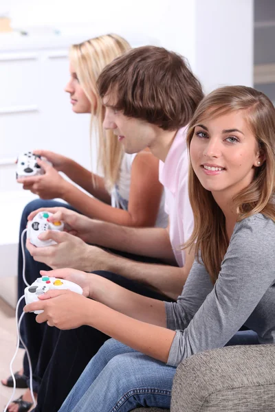Трое подростков играют в видеоигры — стоковое фото