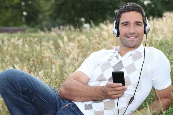 Man listening to music in the countryside — Stock Photo, Image