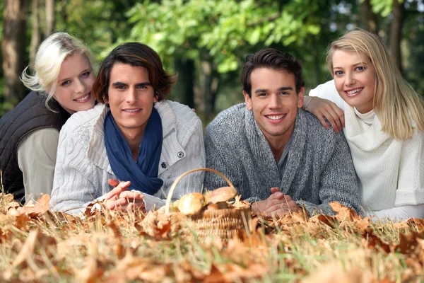 Adults lying in leaves — Stock Photo, Image