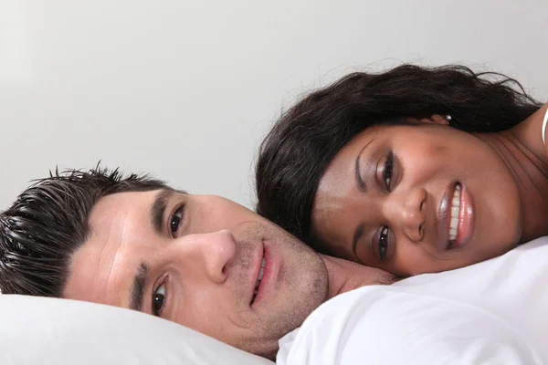 Jovem casal deitado na cama — Fotografia de Stock