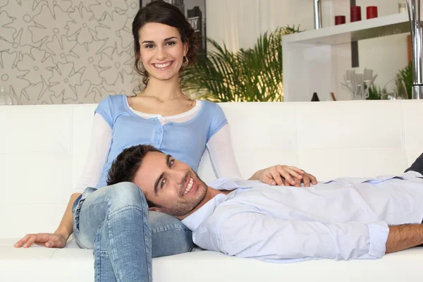 幸せなカップルはソファーの上 — ストック写真