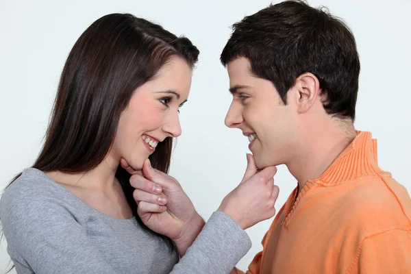 Uomo e donna giocherellona che tengono il mento — Foto Stock