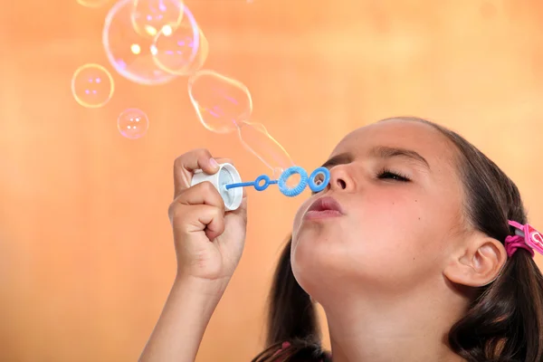 Jong meisje waait bubbels — Stockfoto