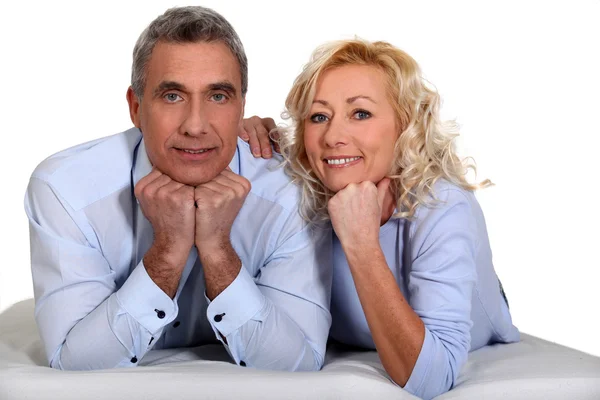 Middle-aged couple laying together Stock Picture