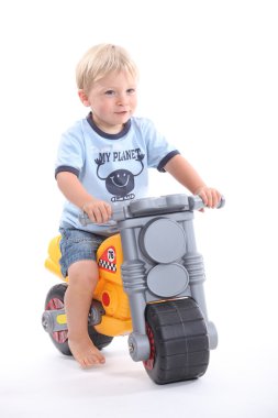 Young boy on a toy bike clipart