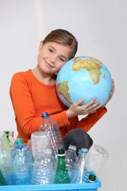 Young girl hugging a globe behind a box of plastic recycling clipart