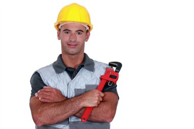 Portrait of tradesman cross-armed holding adjustable spanner clipart