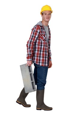 Mason carrying a brick, studio shot clipart