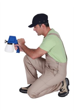 Man using paint spraying device clipart