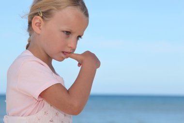 Young girl biting her thumbnail clipart