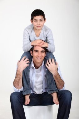 Son sat on father's shoulders clipart