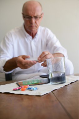 Elderly man taking medication clipart