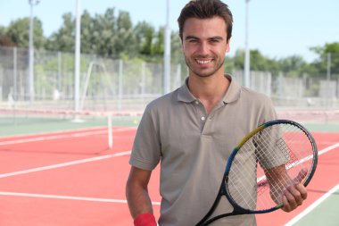 Male tennis player on a hardcourt clipart