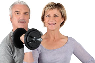 Senior couple training in gym clipart