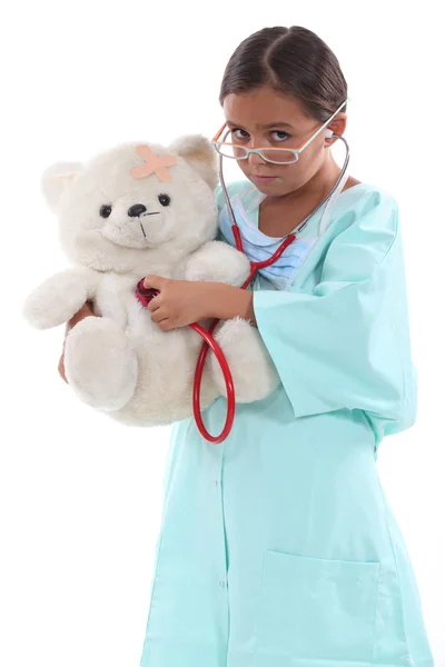 テディー ・ ベアを保持している看護婦として服を着た小さな女の子 — ストック写真