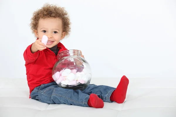 Kleiner Junge isst Bonbons — Stockfoto