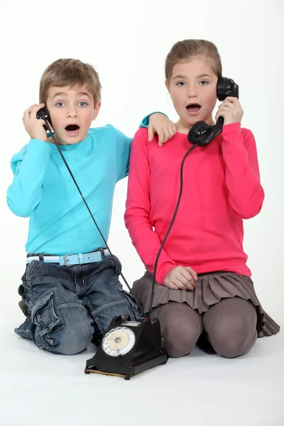 Crianças chocadas usando o telefone — Fotografia de Stock