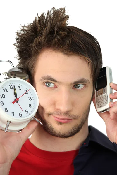 Man met alarmklok en mobiele telefoon — Stockfoto