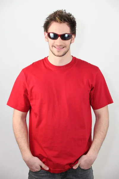 Man gekleed in een rood t-shirt en met een zonnebril — Stockfoto