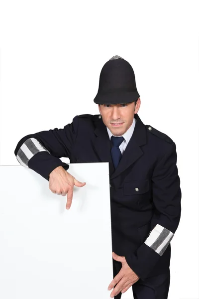 Politieagent naar reclame bord — Stockfoto