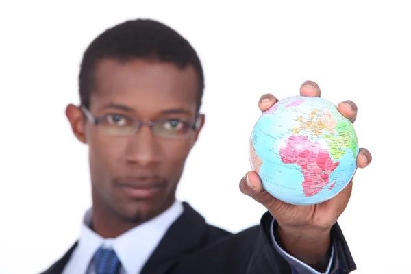 Concept shot of a businessman holding a miniature globe — Stock Photo, Image