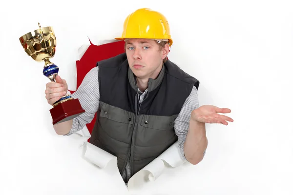 Un ouvrier de la construction tenant une coupe trophée . — Photo