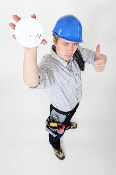 Tradesman approving of the use of smoke detectors — Stock Photo, Image