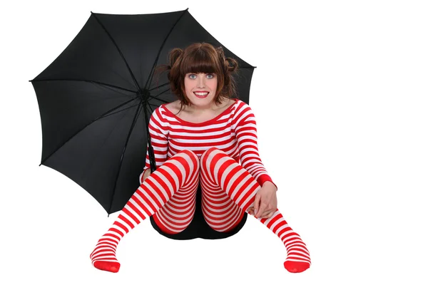 Mujer con ropa a rayas sosteniendo un paraguas — Foto de Stock