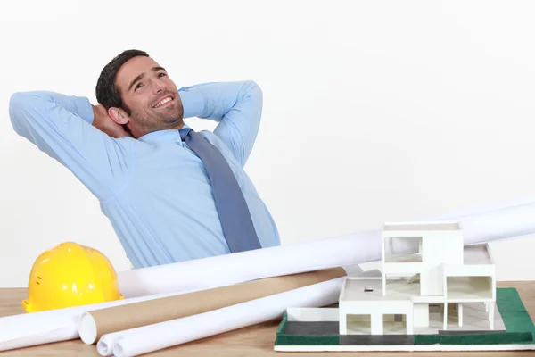 Arquitecto estirándose en su escritorio — Foto de Stock