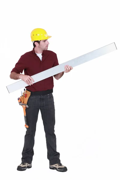 Tradesman holding up a steel girder — Stock Photo, Image