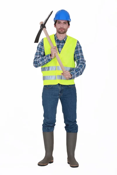 Labourer holding a pickaxe — Stock Photo, Image