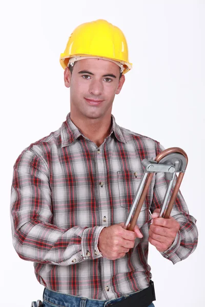 Tradesman usando um bender tubo — Fotografia de Stock