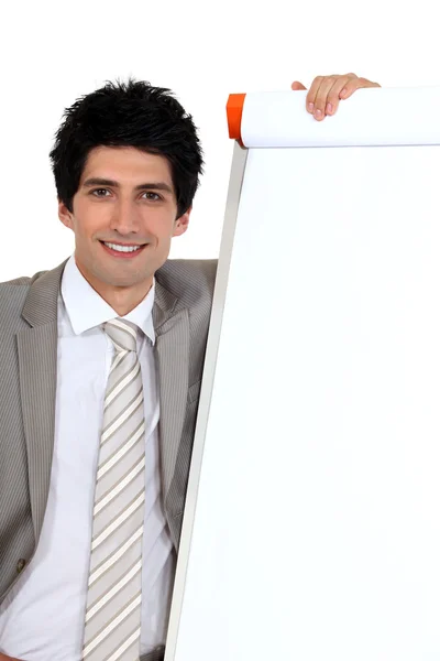 Empresário posando ao lado de uma placa em branco — Fotografia de Stock