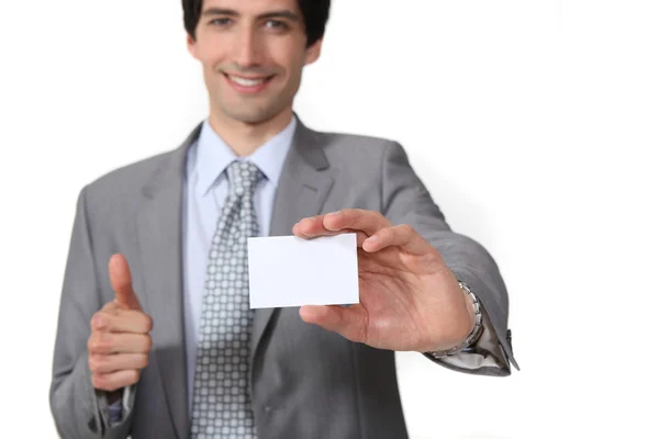 Man making thumbs-up gesture and holding business card — Stock Photo, Image