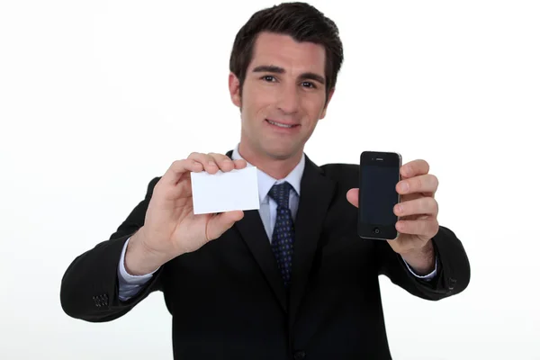 Man holding business-card and mobile telephone — Stock Photo, Image