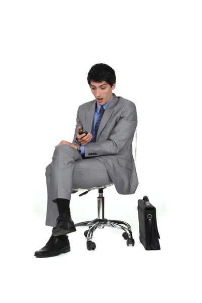 Empresário chocado com seu celular — Fotografia de Stock