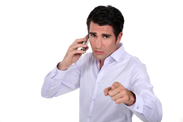 Selbstbewusster Geschäftsmann zeigt beim Telefonieren an — Stockfoto