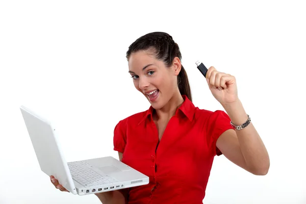Жінка тримає ноутбук і USB ключ — стокове фото