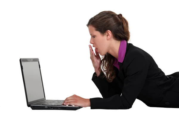 Woman yawning in front of a computer — Stock Photo, Image