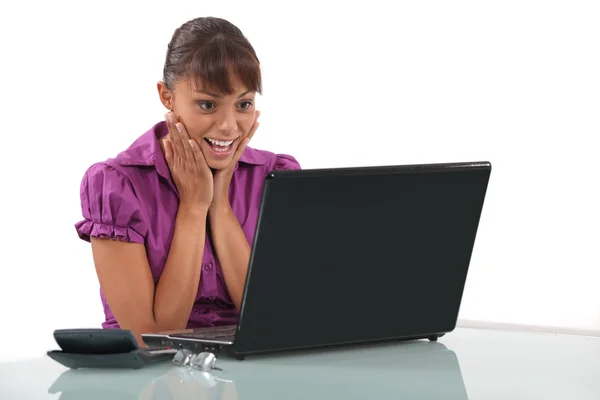 Mulher encantada com seu laptop — Fotografia de Stock