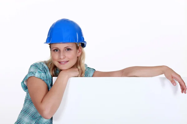Een vrouwelijke bouwvakker met een billboard. — Stockfoto