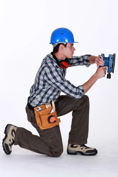 Tradesman utilizzando una levigatrice — Foto Stock