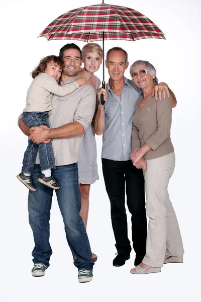 Aile ayakta şemsiyesi altında — Stok fotoğraf
