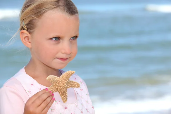 Menina segurando uma estrela do mar — Fotografia de Stock
