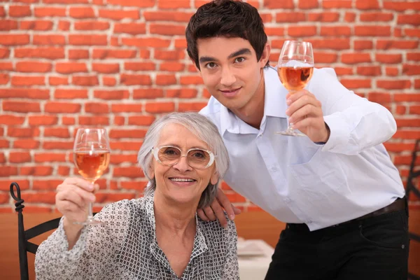 Senior dam och ung man att göra en toast — Stockfoto