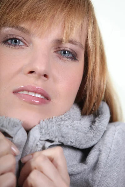 Vrouw in make-up en een knus grijze hooded sweatshirt — Stockfoto
