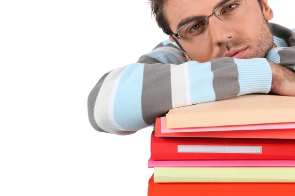 Man leaning on stack of books — Stock Photo, Image