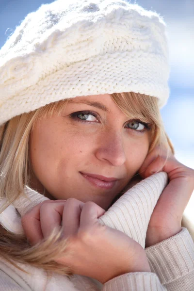 Blonde vrouw in een crème jumper en hoed — Stockfoto