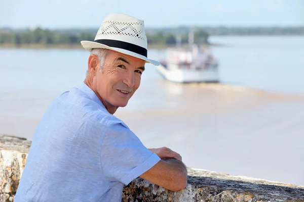 Homem de chapéu de palha a ver uma balsa a atravessar o estuário de Gironde — Fotografia de Stock