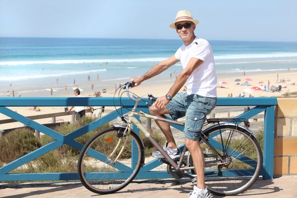 Hombre con una bicicleta en la playa — Foto de Stock